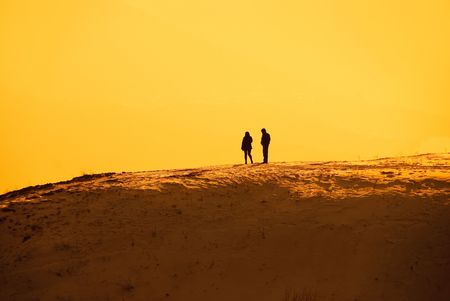 solitude, silhouettes of a man and a woman standing on the hill and talkingの写真素材