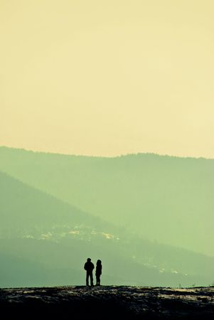 solitude, silhouettes of a man and a woman standing on the hill and talkingの写真素材