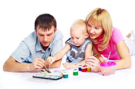 happy young beautiful mother, father and their little son painting with watercolorの写真素材