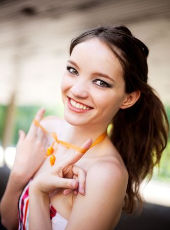 portrait of a happy young laughing girl wearing a necklaceの写真素材