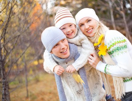 happy young family spending time outdoor in the park (focus on the father)の写真素材