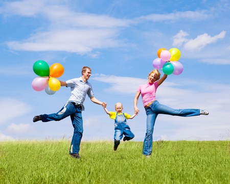 happy family with balloons outdoor on a summer dayの写真素材