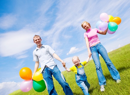 happy family with balloons outdoor on a summer dayの写真素材