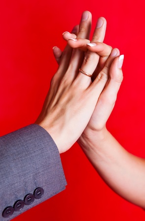 hands of a bride and a groom with golden wedding rings の写真素材