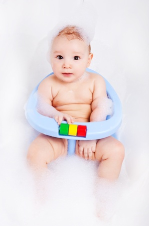 cute six months old baby sitting in the baby bath chair  の写真素材