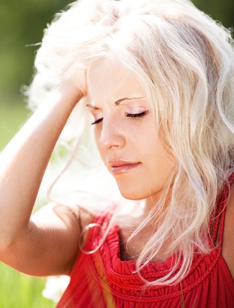 beautiful sad  woman  on the  meadow on a warm summer dayの写真素材