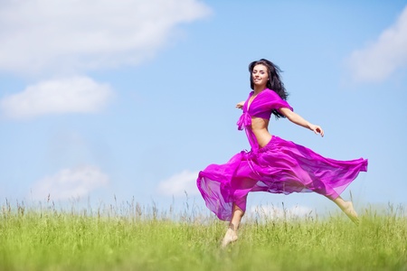happy jumping young woman  outdoor on a summer dayの写真素材