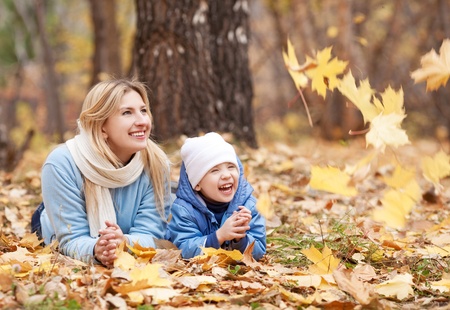 happy young mother and her son spending time in the autumn parkの写真素材