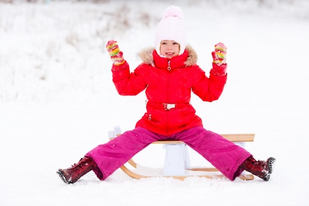 happy little girl with the sledge outdoor on a winter day