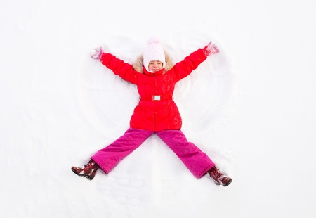 Girl Laying On the Ground Making Snow Angelの写真素材