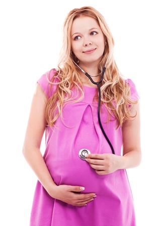 beautiful young pregnant woman with a stethoscope, isolated against white backgroundの写真素材