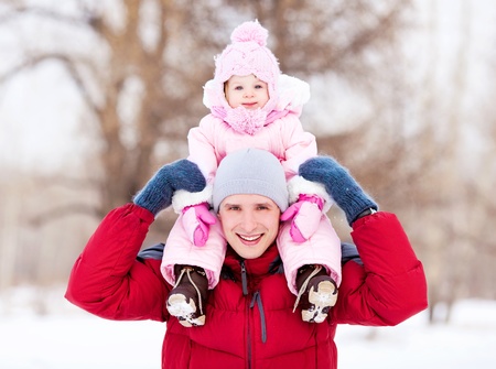 happy young father with his daughter spending time outdoor in the winter park の写真素材