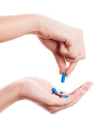 hands of a woman holding pills, isolated against white backgroundの写真素材