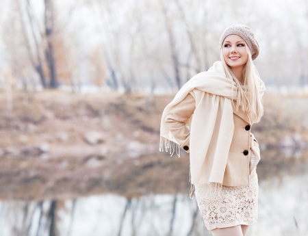 beautiful young blond woman spending time in the autumn park  の写真素材