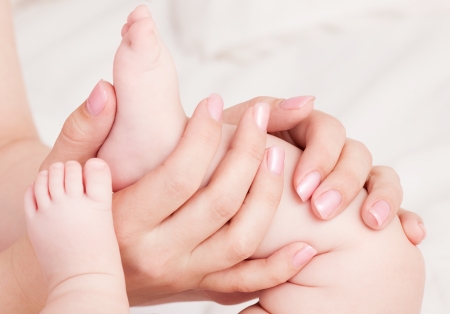 hands of amother massaging her babyの写真素材