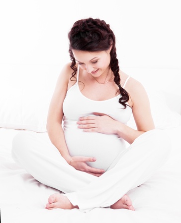 beautiful young pregnant woman in bed at home  の写真素材