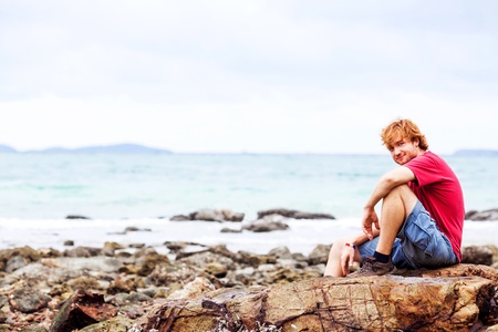 young man sleeping on the beachの写真素材