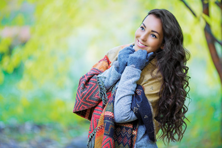 beautiful young brunette woman having a walk in the autumn parkの写真素材