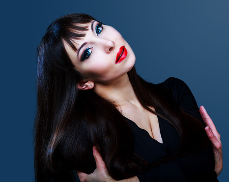 studio portrait of a brunette model with long hair and bright makeupの写真素材