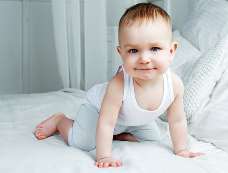 cute baby boy in bed at homeの写真素材