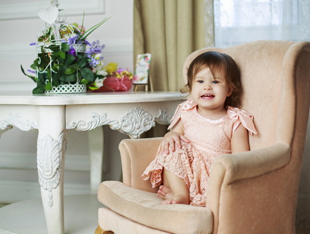 happy laughing baby sitting in the chair at homeの写真素材