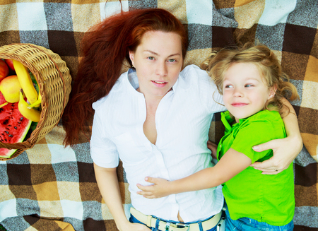 happy young mother and son having a picnic outdoor on a summer dayの写真素材