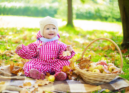 happy baby girl having a picnic in the autumn parkの写真素材