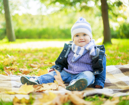 happy boy relaxing in the autumn parkの写真素材