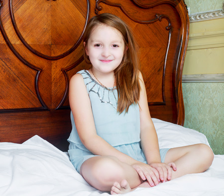 happy smiling girl in bed at homeの写真素材