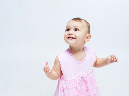portrait of a cute baby looking up, isolated against light blue backgroundの写真素材