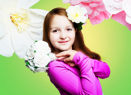 studio portrait of a beautiful girl with a bouquet and floral backgroundの写真素材