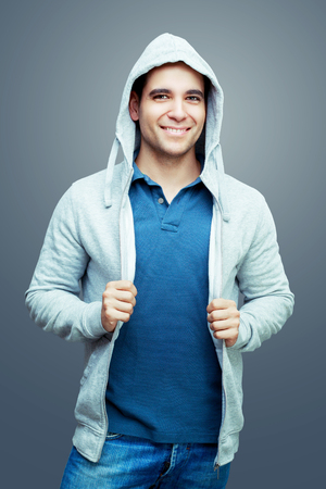 young handsome smiling man, isolated against gray backgroundの写真素材