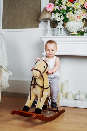 happy boy play at home with a toy horseの写真素材