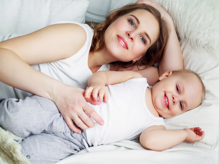 happy beautiful mother with her one year old son, studio shotの写真素材