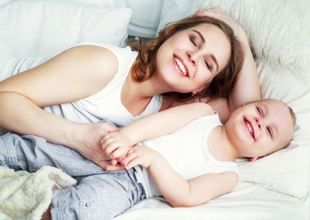 happy beautiful mother with her one year old son, studio shotの写真素材
