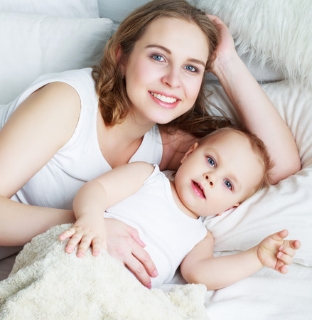 happy beautiful mother with her one year old son, studio shotの写真素材