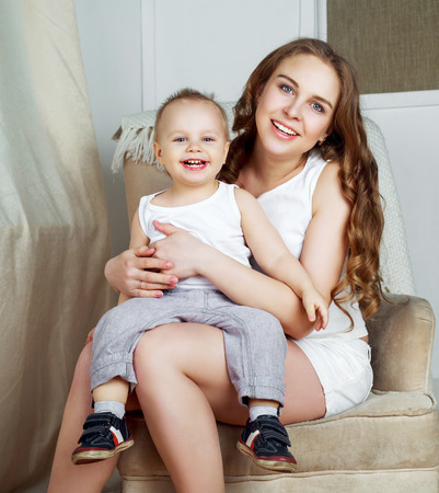 happy beautiful mother with her one year old son, studio shotの写真素材