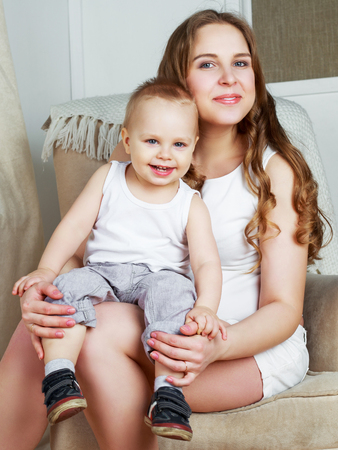 happy beautiful mother with her one year old son, studio shotの写真素材