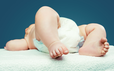 baby wearing diapers, against blue studio backgroundの写真素材