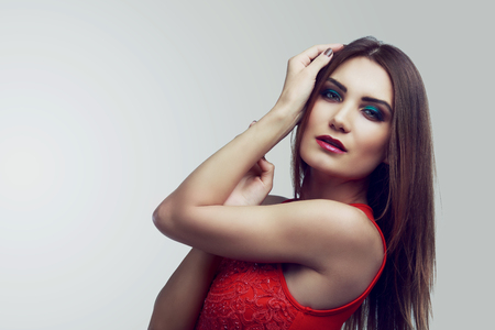 beautiful  young  woman,wearing a   red dress,  isolated against white backgroundの写真素材