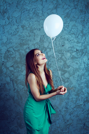 excited happy young  woman with a balloon   isolated against white backgroundの写真素材