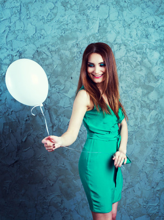 excited happy young  woman with a balloon   isolated against white backgroundの写真素材
