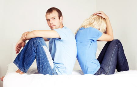 husband and wife have a quarrel at home,  sit on the bedの写真素材