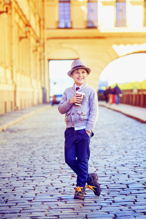 happy stylish boy with cofee in the city streetの写真素材