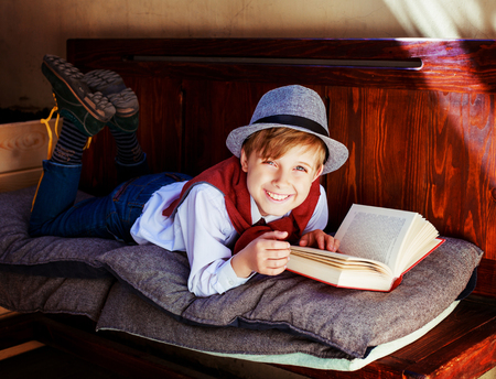 happy stylish boy with a book on the benchの写真素材