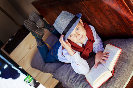 happy stylish boy with a book on the benchの写真素材