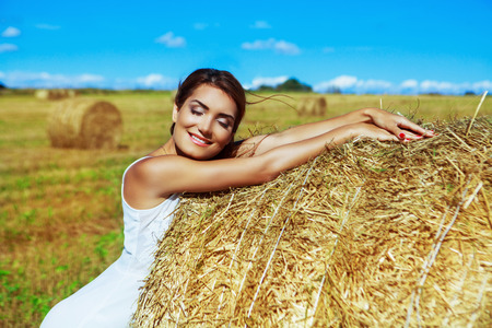 beautiful woman in the harvested  wheat field in august on a sunny dayの写真素材