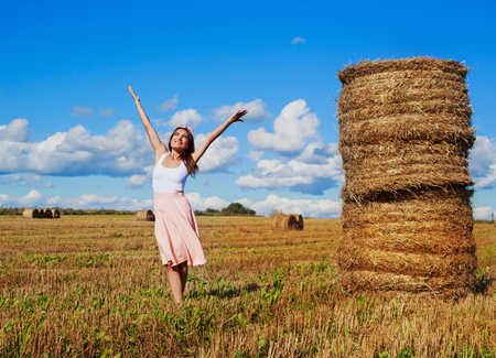 beautiful woman in the harvested  wheat field in august on a sunny dayの写真素材