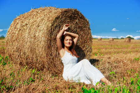 beautiful woman in the harvested  wheat field in august on a sunny dayの写真素材