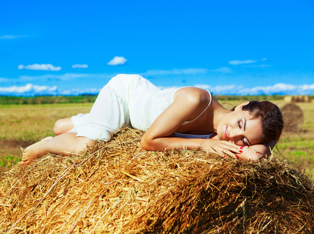 beautiful woman in the harvested  wheat field in august on a sunny dayの写真素材